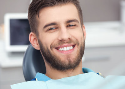 man smiling in a dental chair