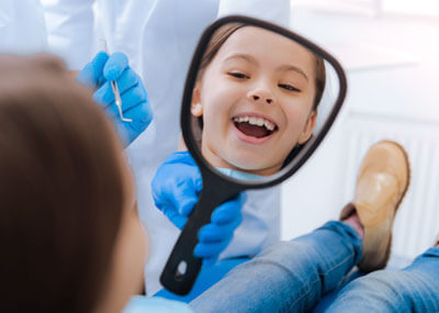 child smiling in a dental chair